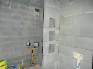 Kylpyhuoneeseen sisustussuunnittelija suunnitteli ammeen ja suihkun väliin seinän, joka toimii myös hyllynä.